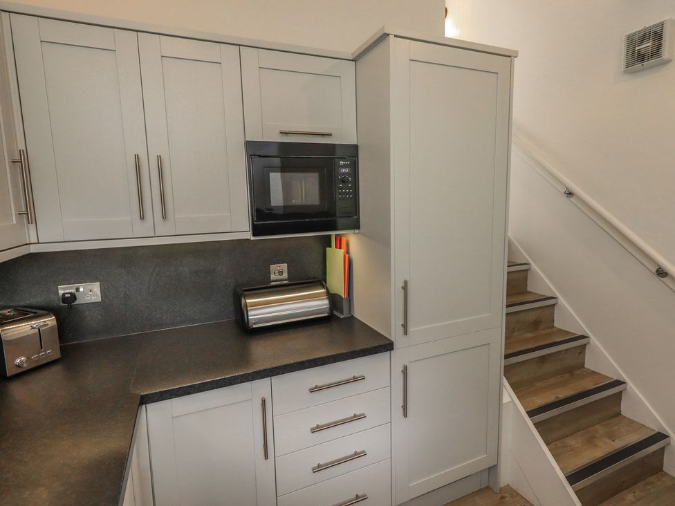 A kitchen with cabinets and appliances at Acorn in Bowness-on-Windermere