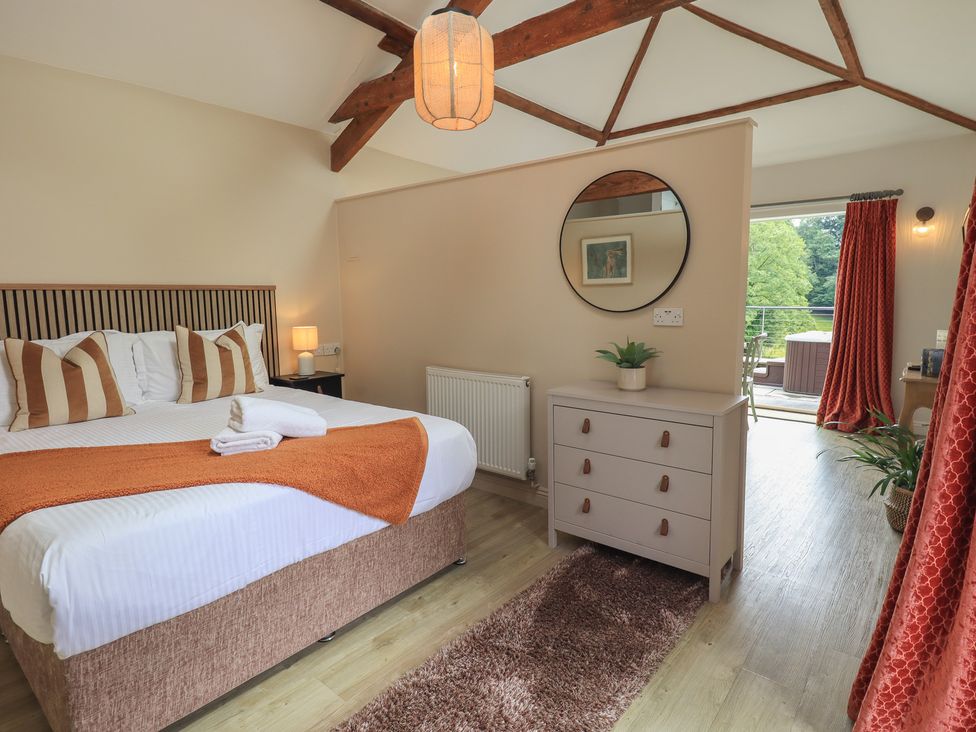 A bedroom with a bed and dresser at Acorn in Bowness-on-Windermere