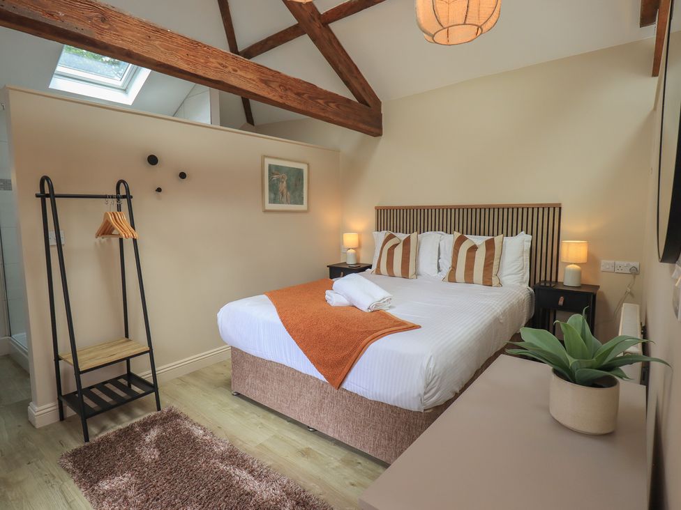 A bedroom with a double bed and wooden beams at Acorn in Bowness-on-Windermere