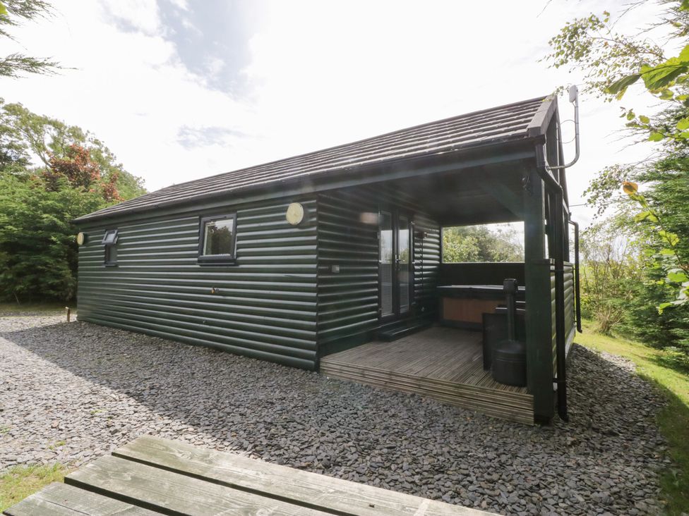 A cabin with a deck and gravel area at Ash Lodge in Pennington near Ulverston