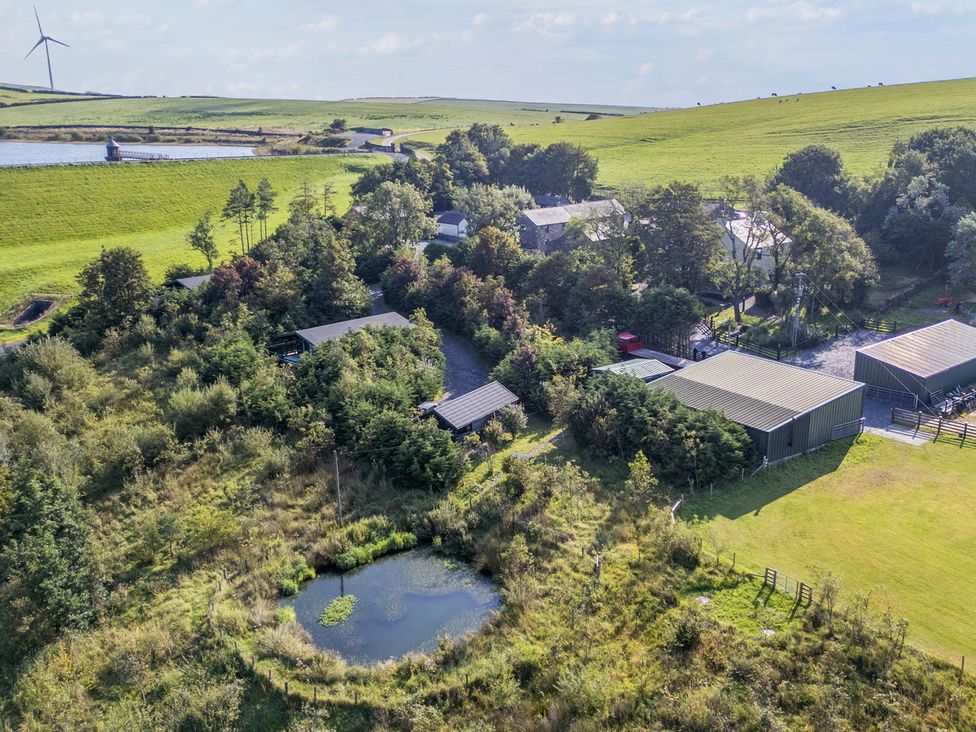 An outdoor area with a pond and farm buildings at Ash Lodge Pennington near Ulverston