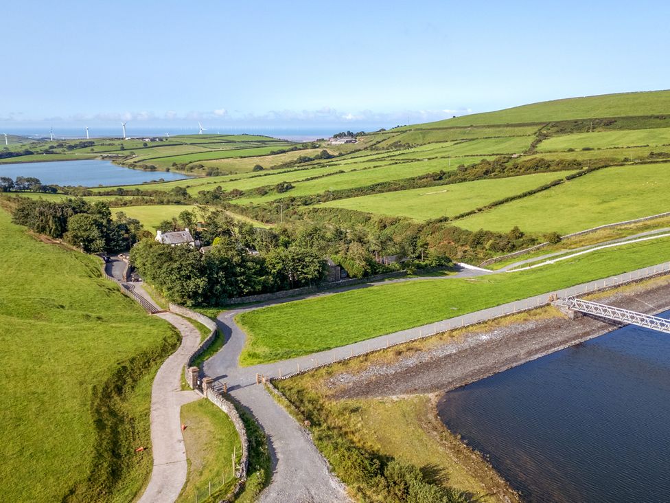 A landscape view featuring a lake, road, and fields at Ash Lodge in Pennington near Ulverston