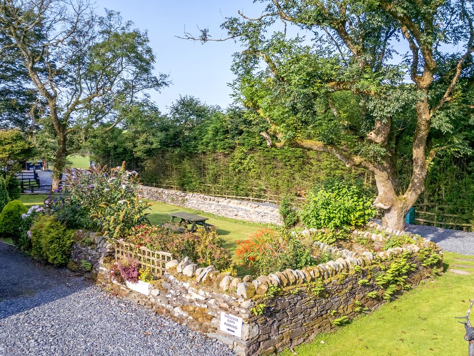 A garden with a picnic table and stone wall at Ash Lodge in Pennington near Ulverston