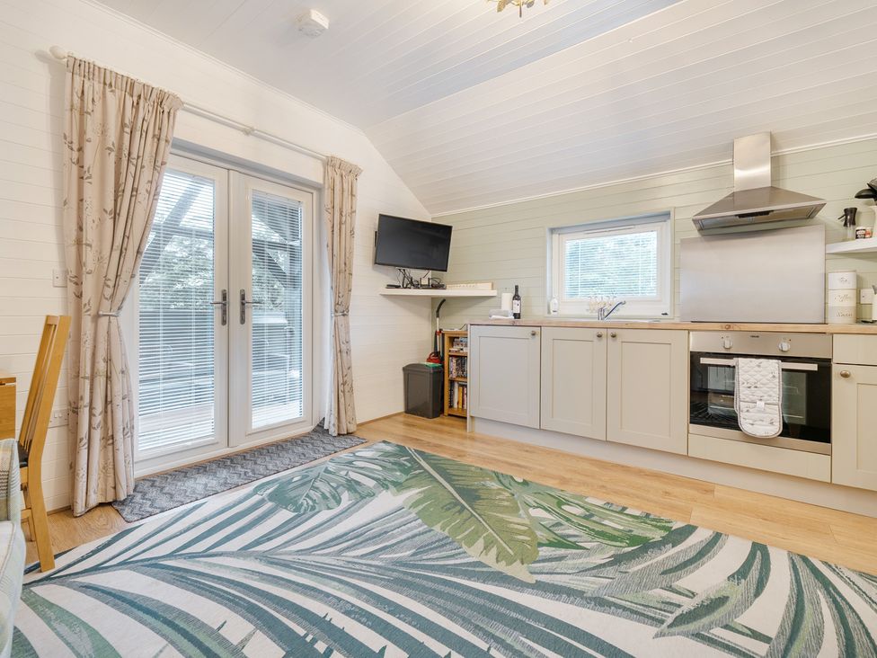 A kitchen with cabinets and a television at Ash Lodge in Pennington near Ulverston