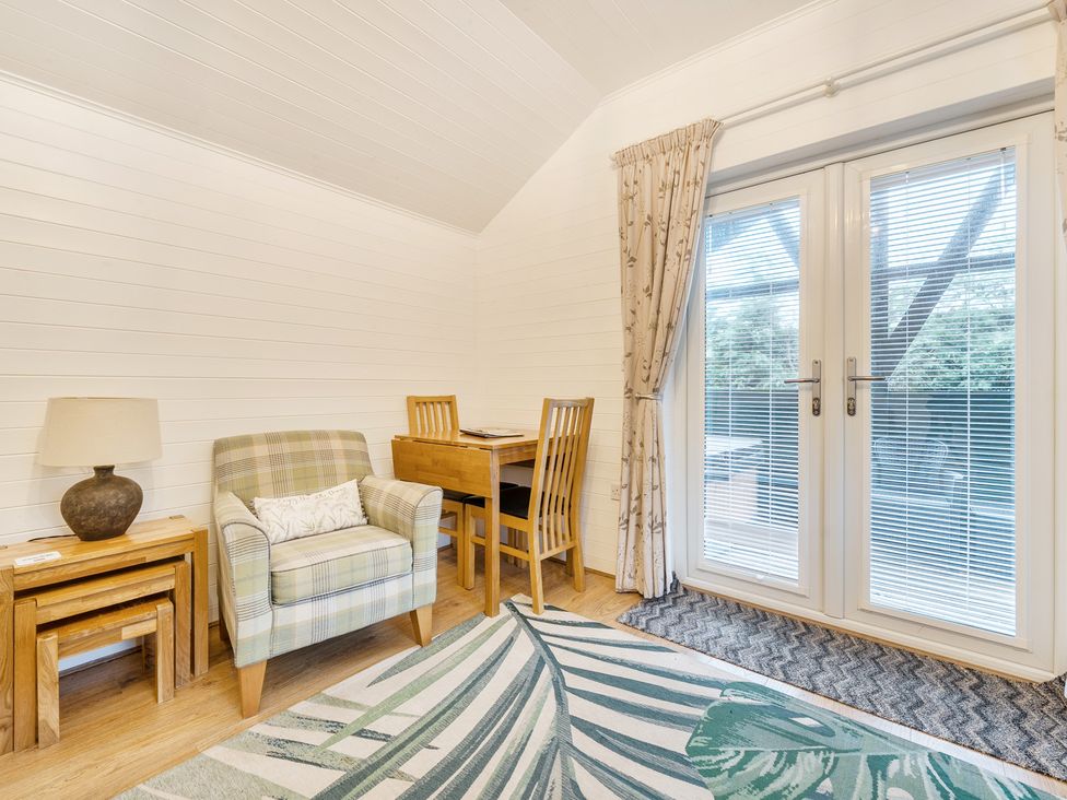 A living room with a chair and table at Ash Lodge Pennington near Ulverston