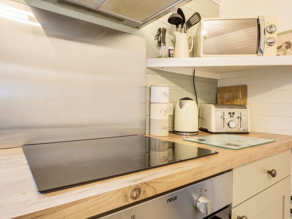 A kitchen with a stovetop and appliances at Ash Lodge Pennington near Ulverston