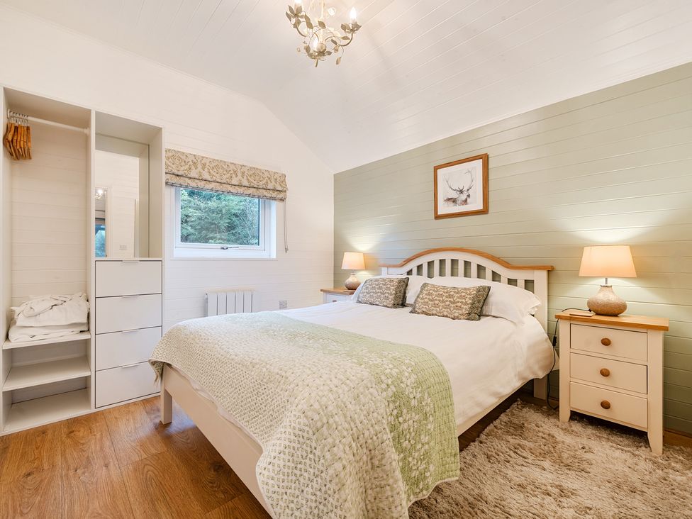 A bedroom with a bed and a wardrobe at Ash Lodge in Pennington near Ulverston
