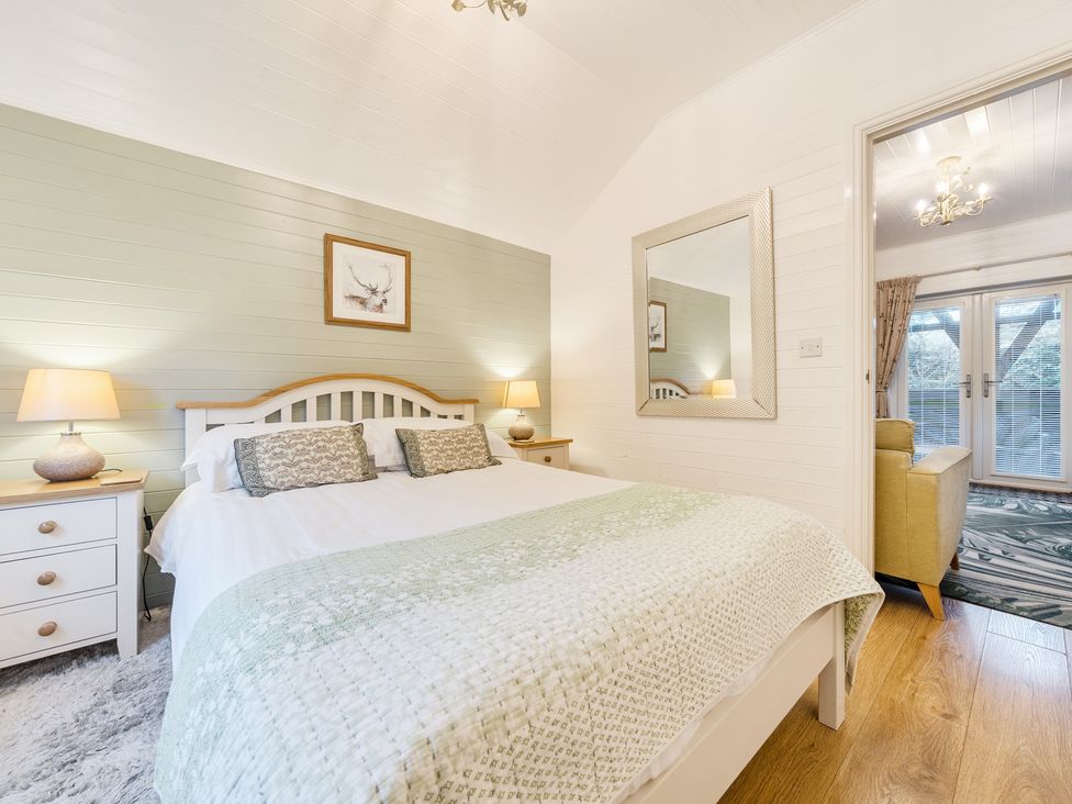 A bedroom with a bed and nightstand at Ash Lodge in Pennington near Ulverston