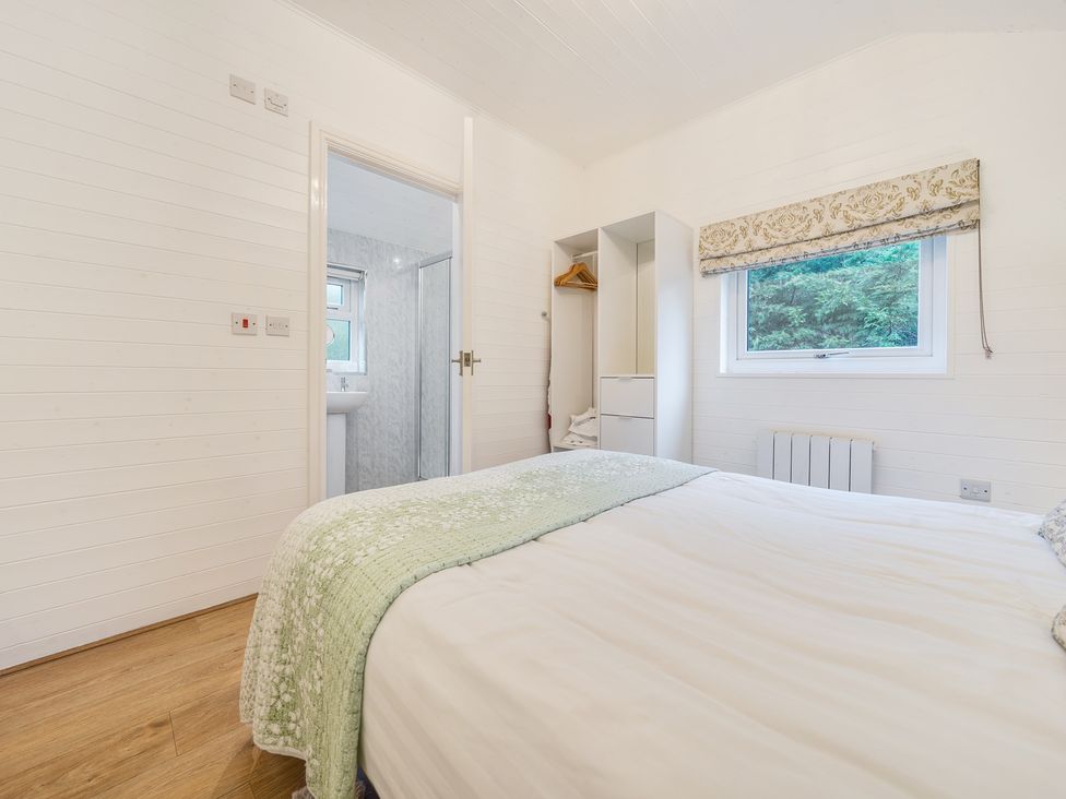 A bedroom with a bed and cabinets at Ash Lodge in Pennington near Ulverston