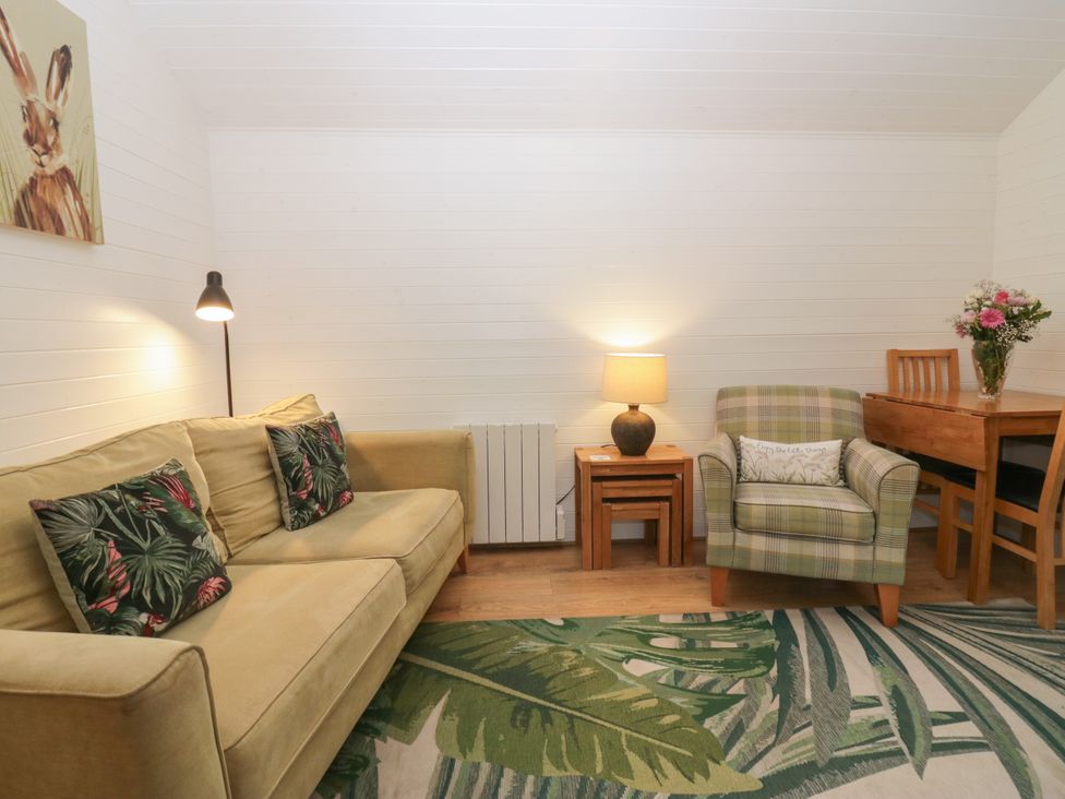A living room with a sofa and armchair at Ash Lodge in Pennington near Ulverston