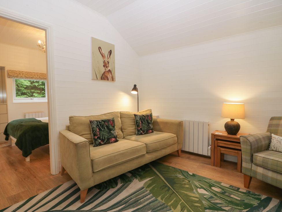 A living room with a sofa and lamp at Ash Lodge in Pennington near Ulverston