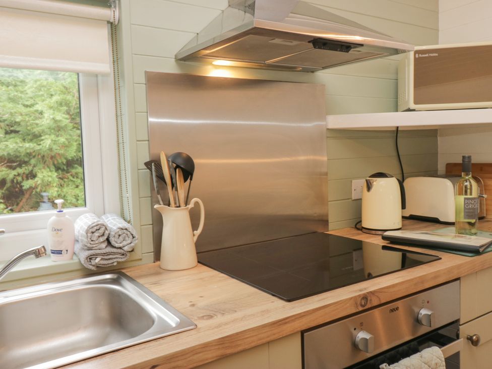 A kitchen with a stove, sink and utensils at Ash Lodge Pennington near Ulverston