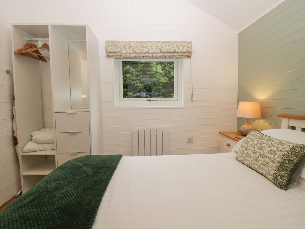 A bedroom with a bed and wardrobe at Ash Lodge Pennington near Ulverston