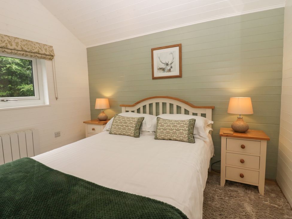 A bedroom with a bed and nightstands at Ash Lodge Pennington near Ulverston