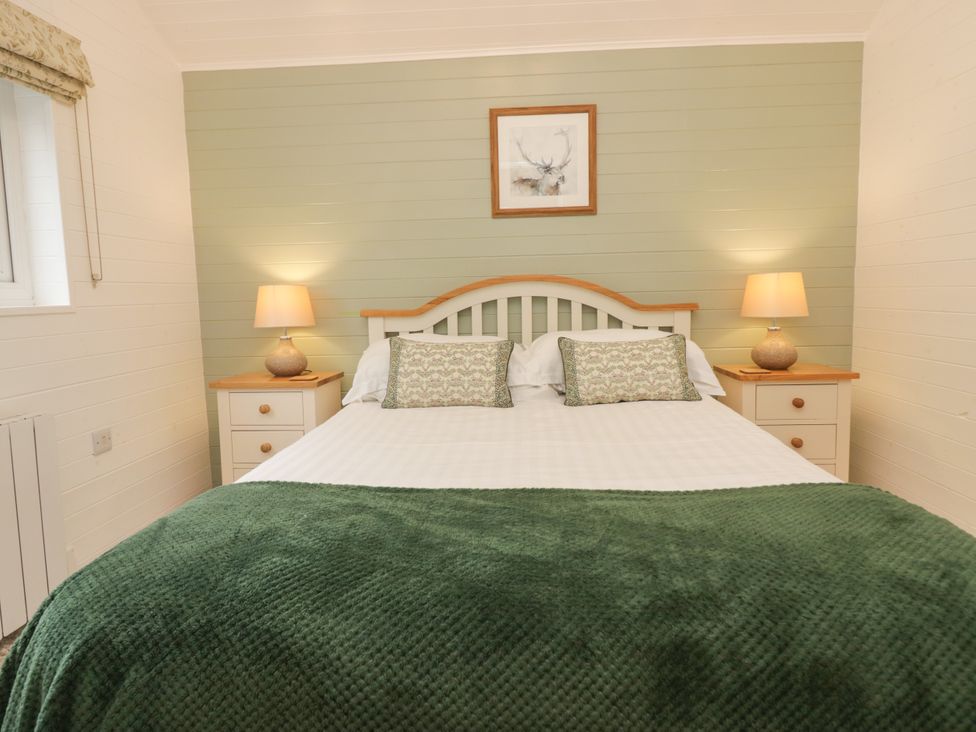 A bedroom with a bed and bedside tables at Ash Lodge Pennington near Ulverston