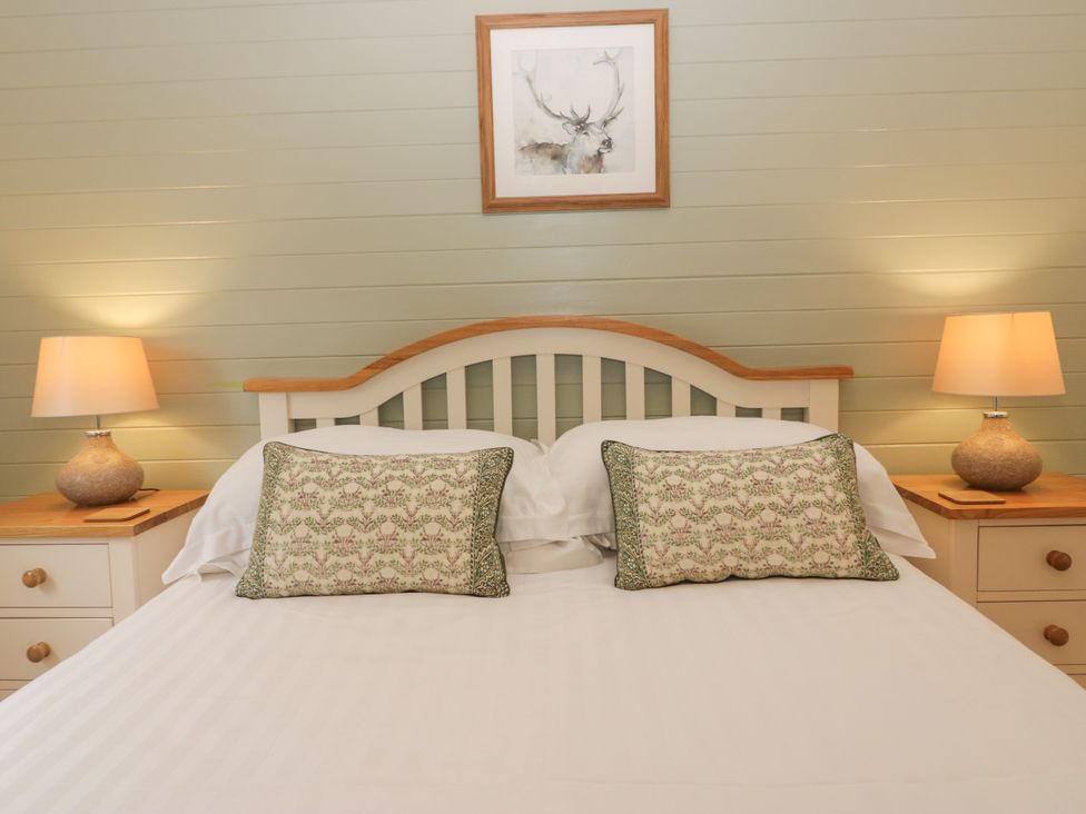 A bedroom with a bed and lamps at Ash Lodge Pennington near Ulverston