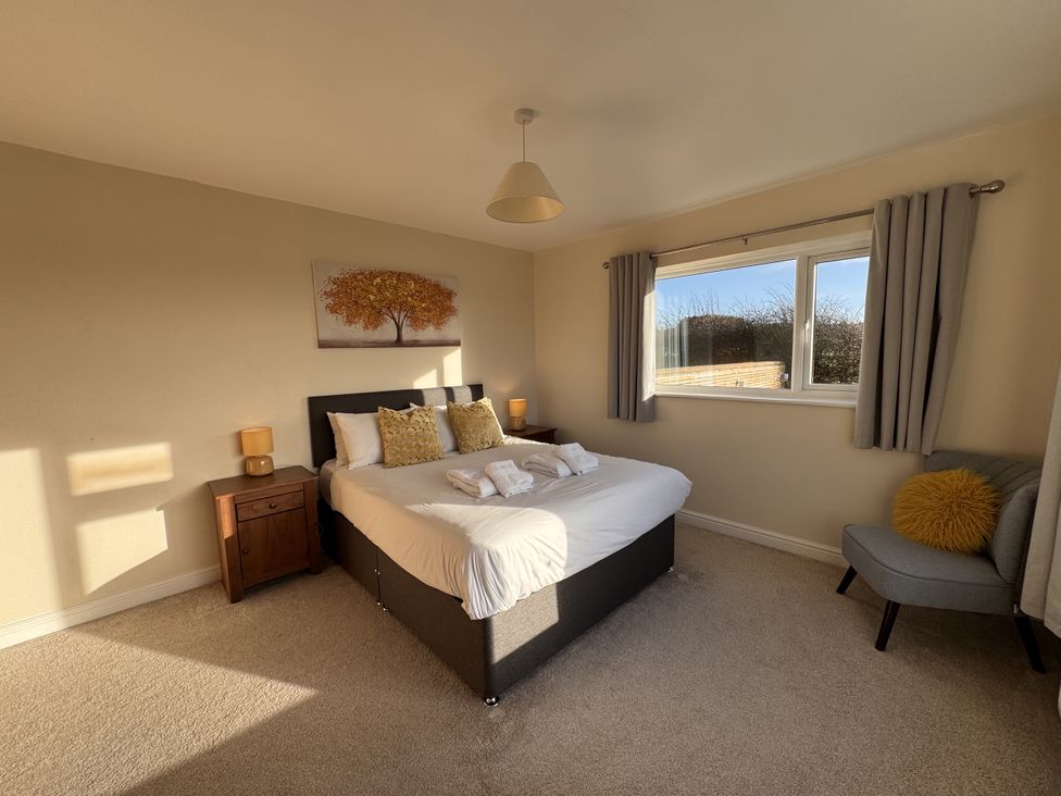 A bedroom with a bed and window at Rhos Helyg Penysarn near Amlwch