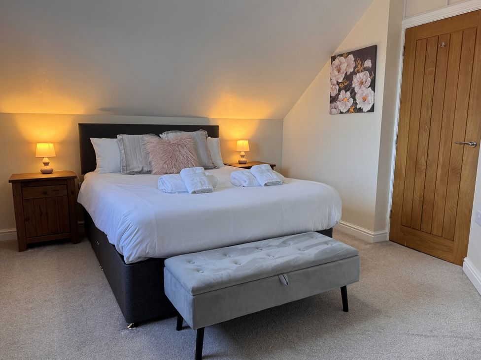 A bedroom with a bed and nightstand at Rhos Helyg Penysarn near Amlwch