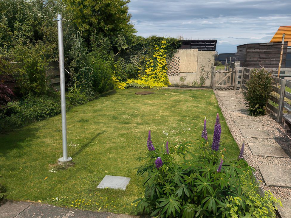 A garden with grass and flowers at 5 Distillery Cottages in Banff