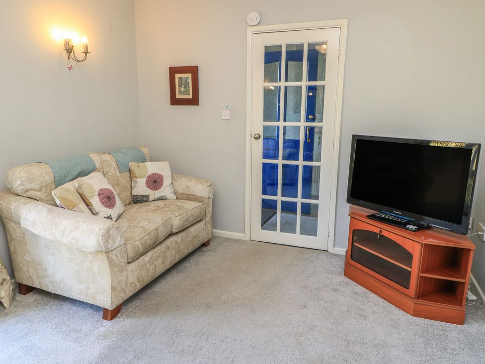 A living room with a sofa and a television at Lamora in Cheddar