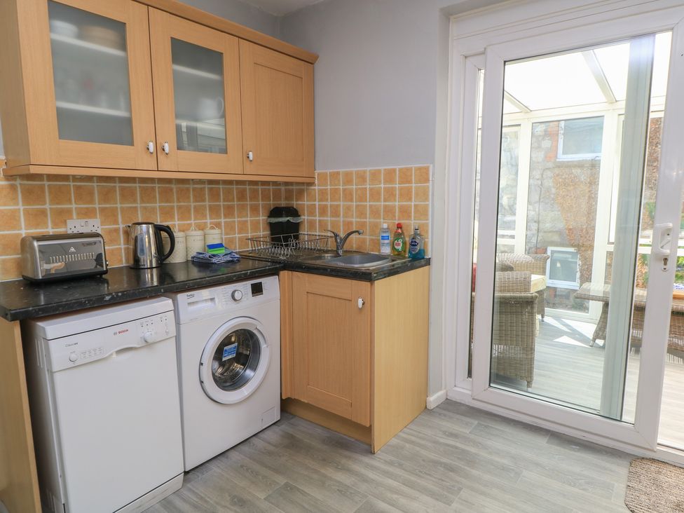 A kitchen with a washing machine and a dishwasher at Lamora in Cheddar