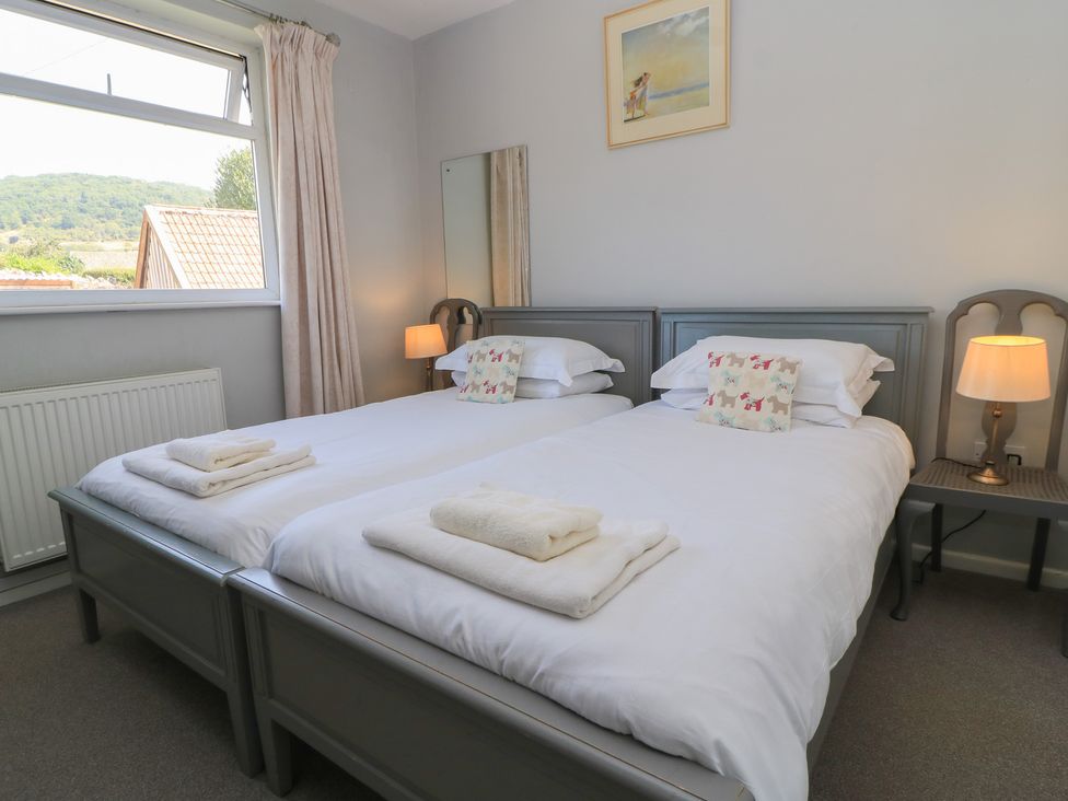 A bedroom with two beds and a bedside table at Lamora in Cheddar