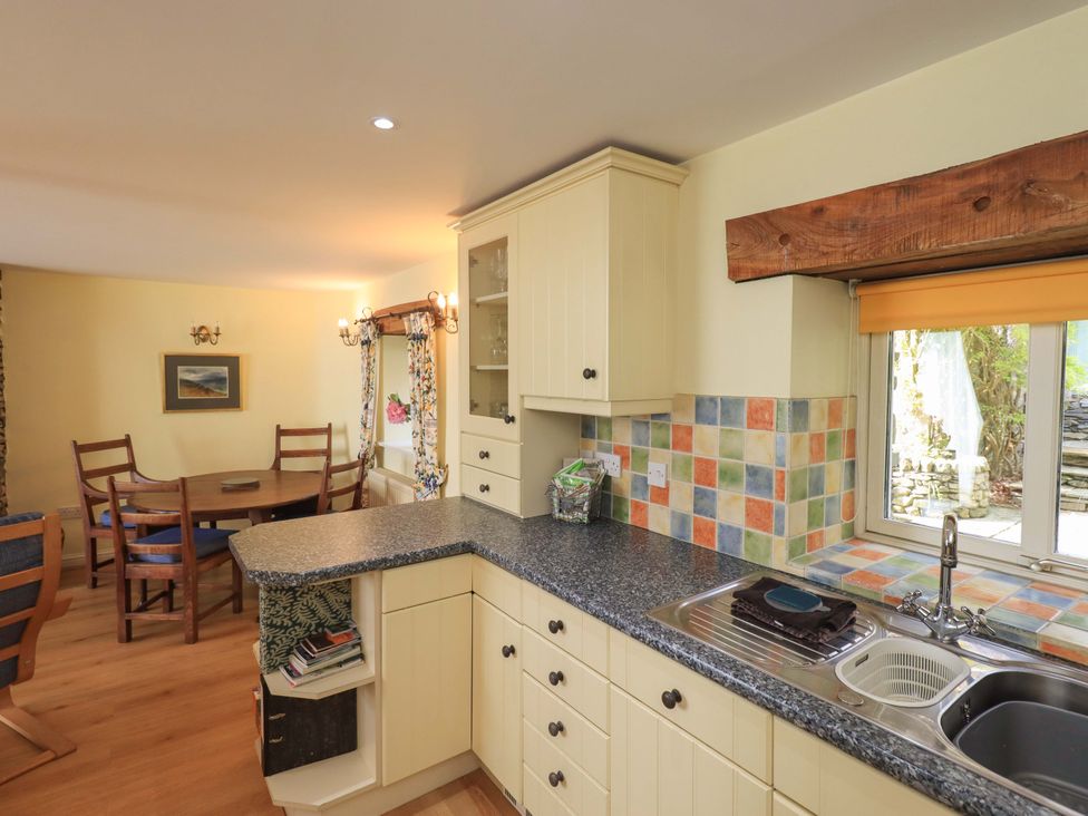 A kitchen with a sink and cabinets at Pheasant Cottage Beckside near Cartmel