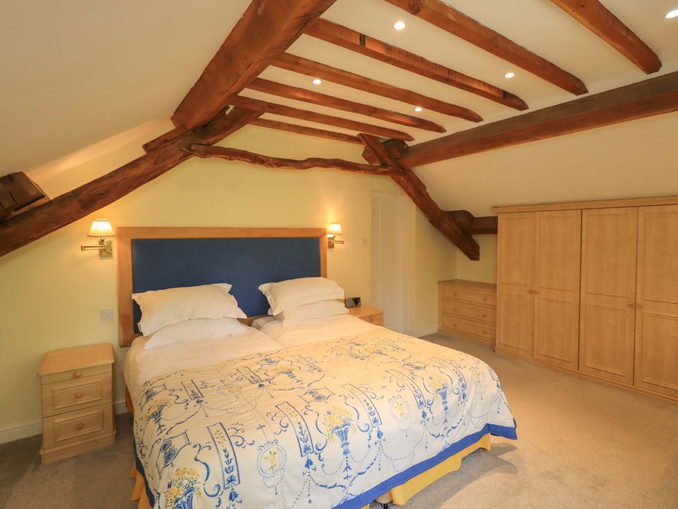 A bedroom with a bed and nightstand at Pheasant Cottage Beckside near Cartmel