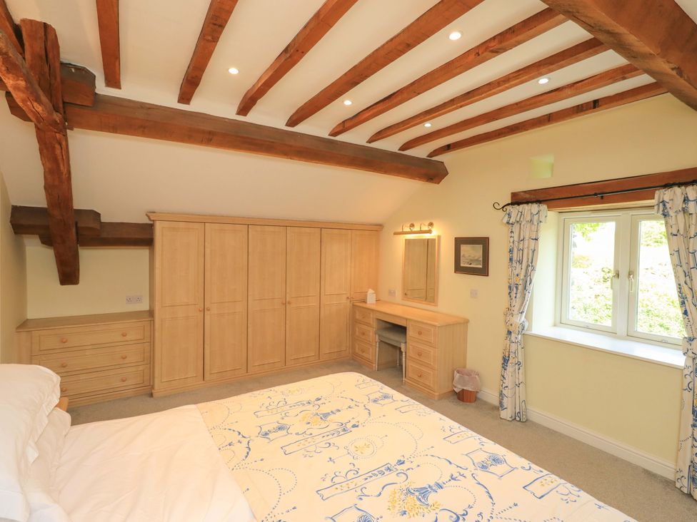 A bedroom with wardrobe and dresser at Pheasant Cottage in Beckside near Cartmel