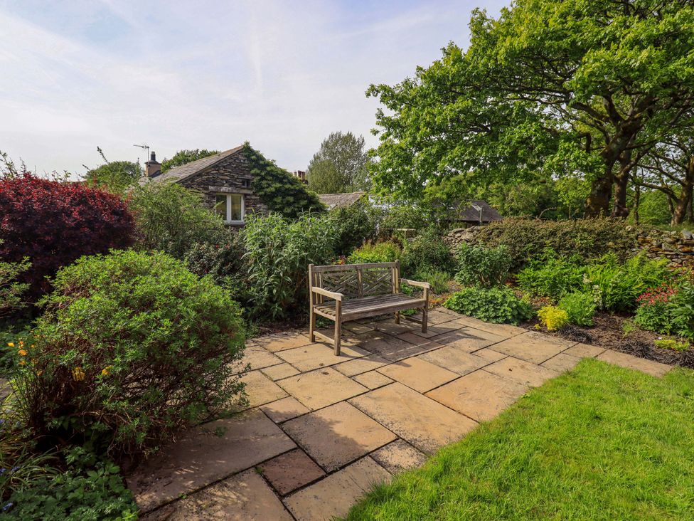 A garden with a bench and various plants at Pheasant Cottage in Beckside near Cartmel