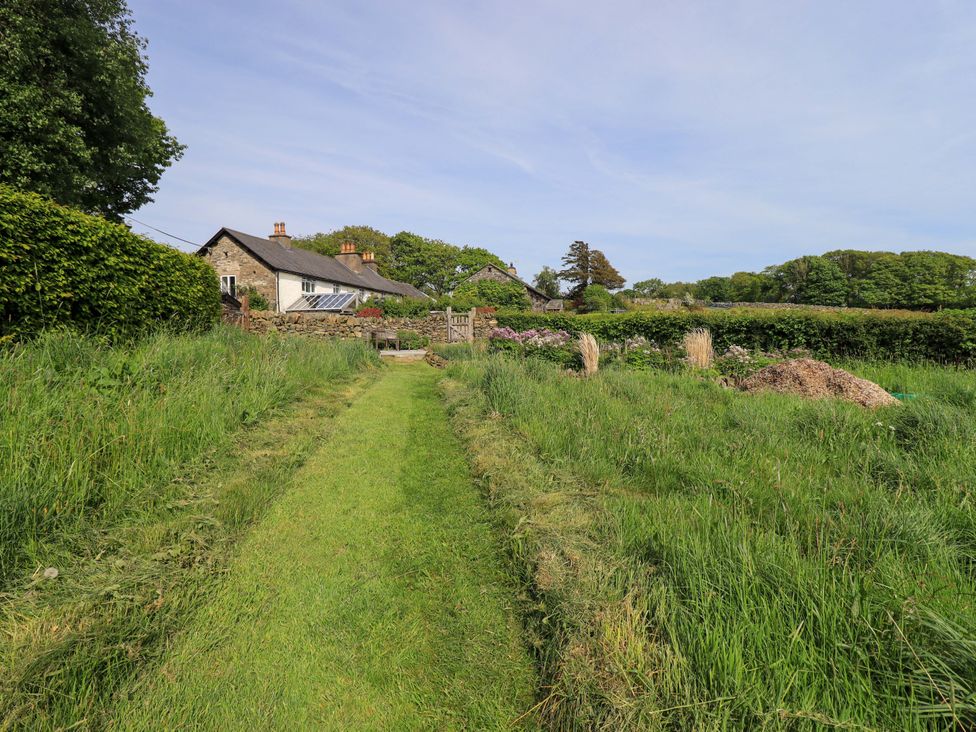 A house in a garden with a pathway at Pheasant Cottage Beckside near Cartmel