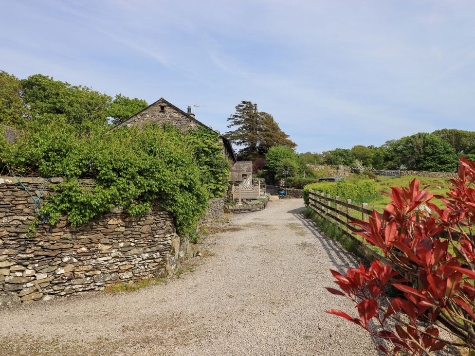 A gravel path leading to a house with stone walls at Pheasant Cottage Beckside near Cartmel