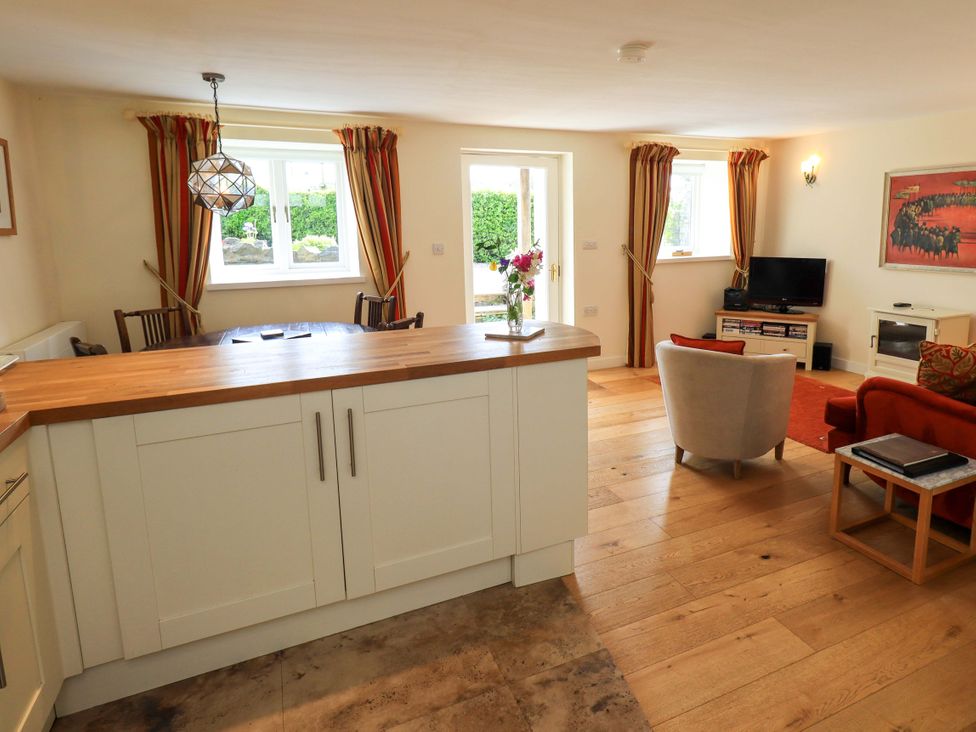 A living room with a sofa and television at Kestrel Cottage, Beckside near Cartmel