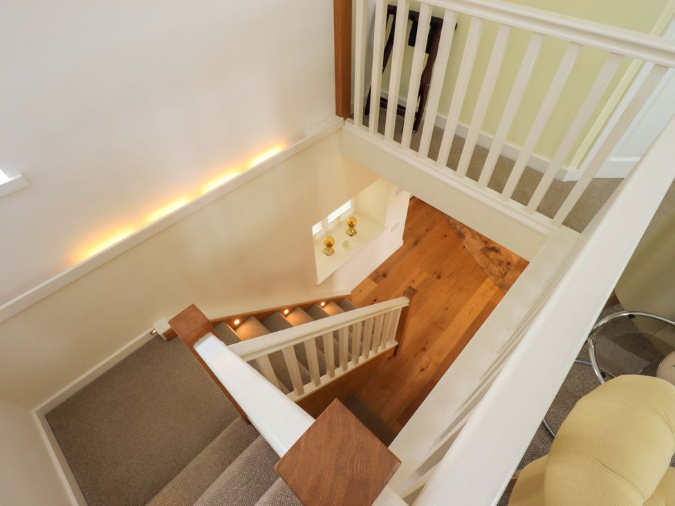 A staircase leading to the upper level at Kestrel Cottage in Beckside near Cartmel