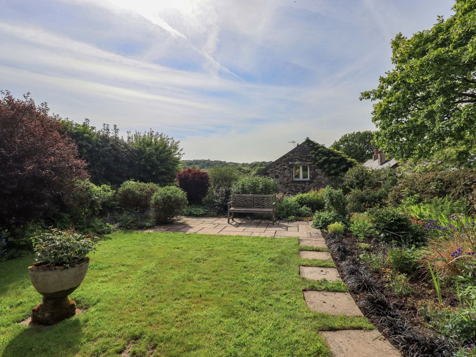 A garden with a bench and pathway at Kestrel Cottage near Cartmel