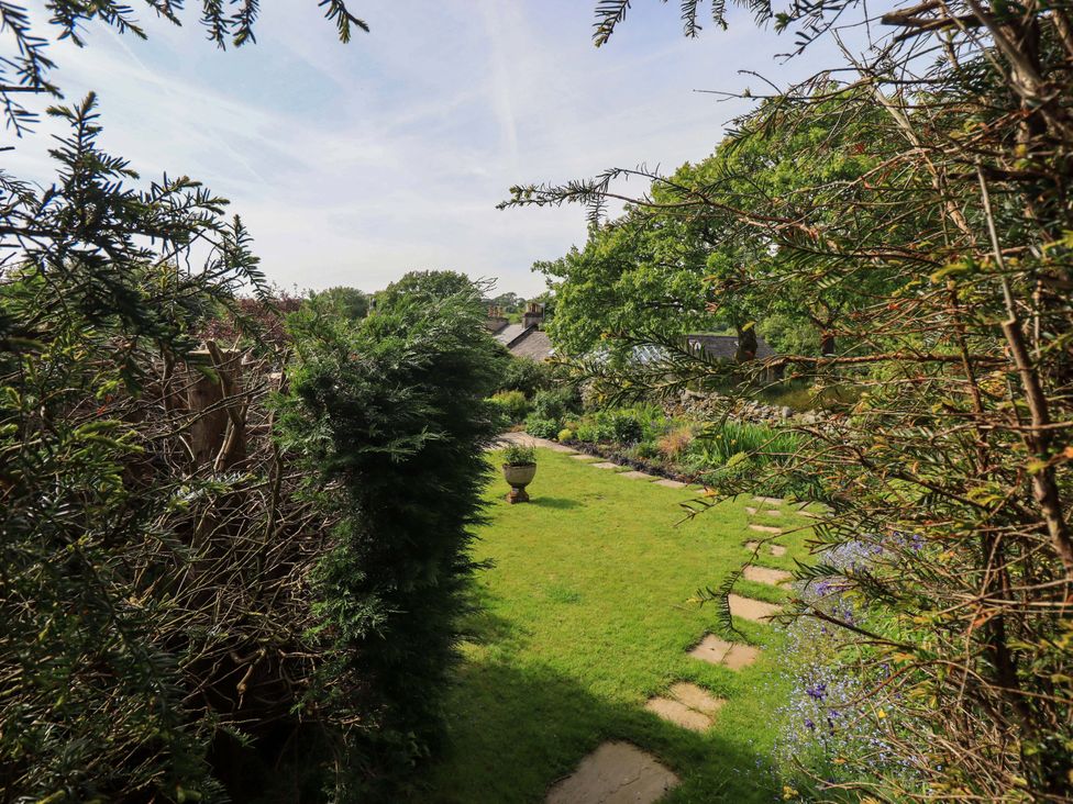 A garden with a pathway and greenery at Kestrel Cottage in Beckside near Cartmel
