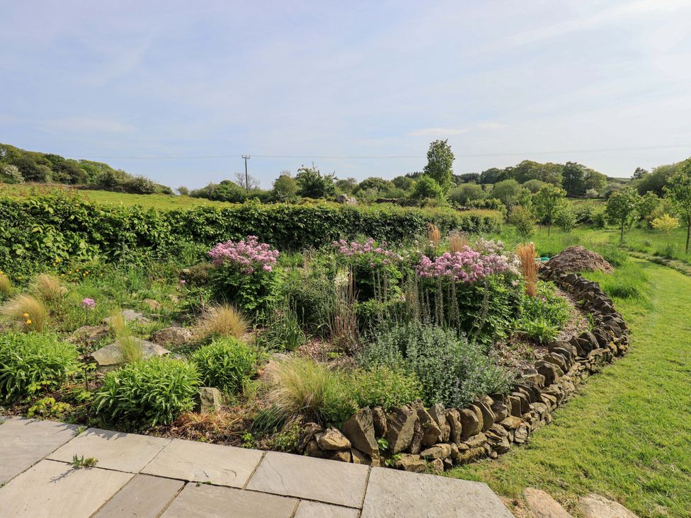 A garden with flowers and rock borders at Kestrel Cottage Beckside near Cartmel