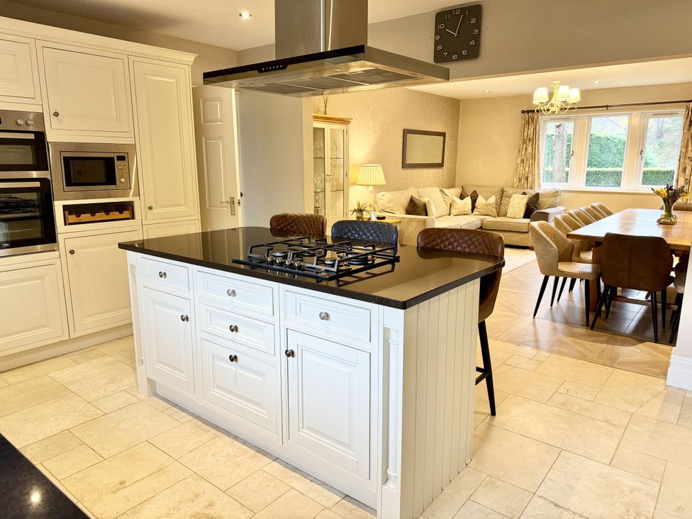 A kitchen with an island and dining area at Willow Brook in Glossop