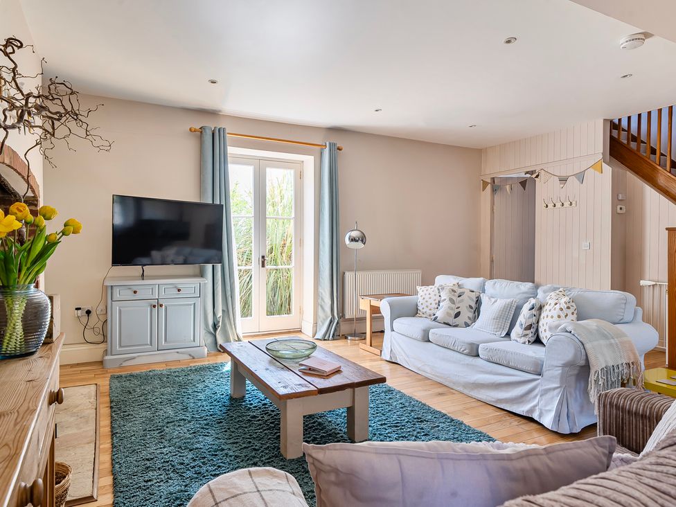 A living room with a sofa and television at East Wing in Crewkerne