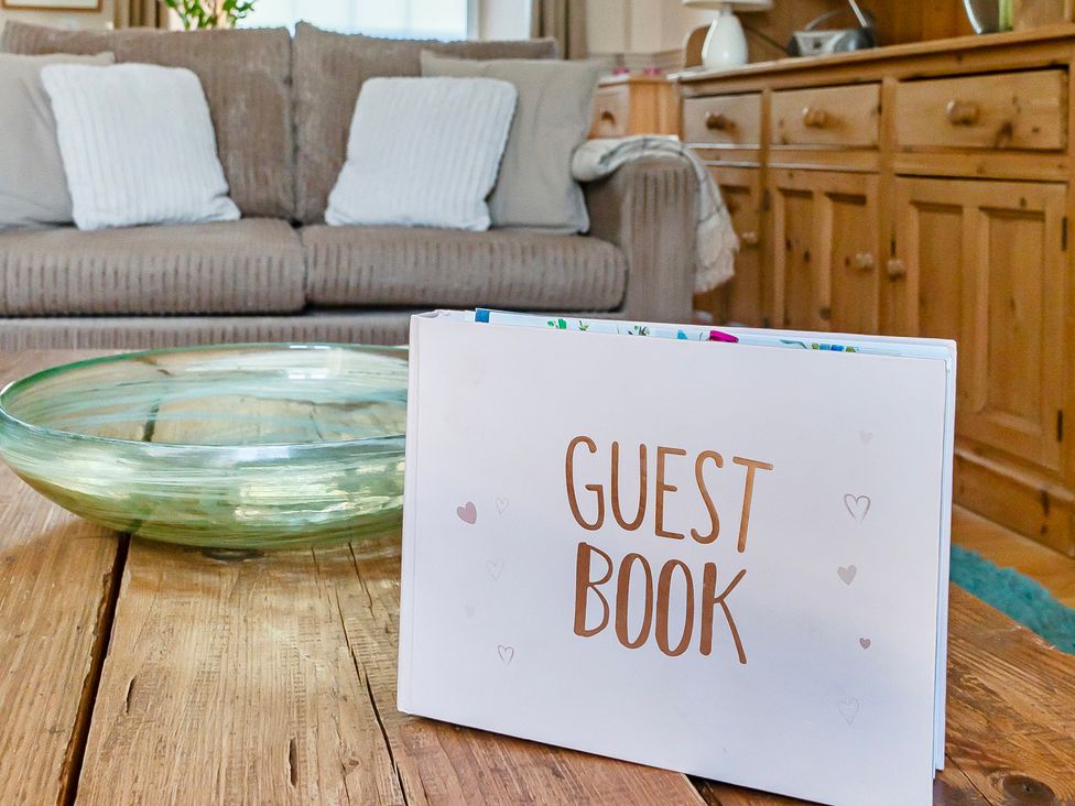 A living room with a guest book and a bowl on a coffee table at East Wing in Crewkerne