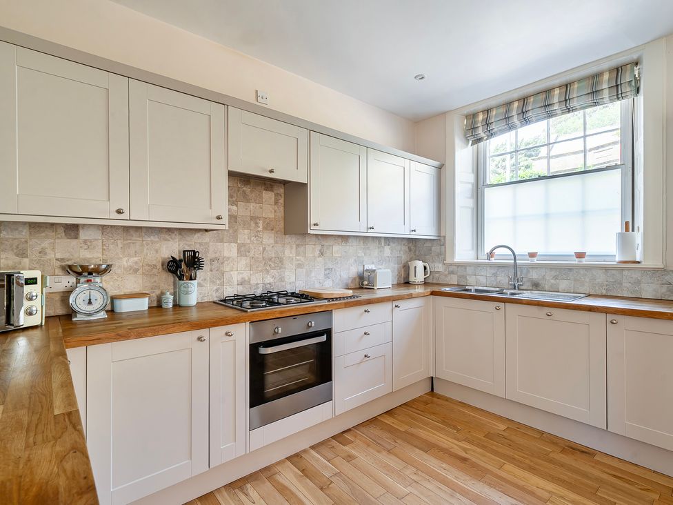 A kitchen with cabinets and stove at East Wing in Crewkerne
