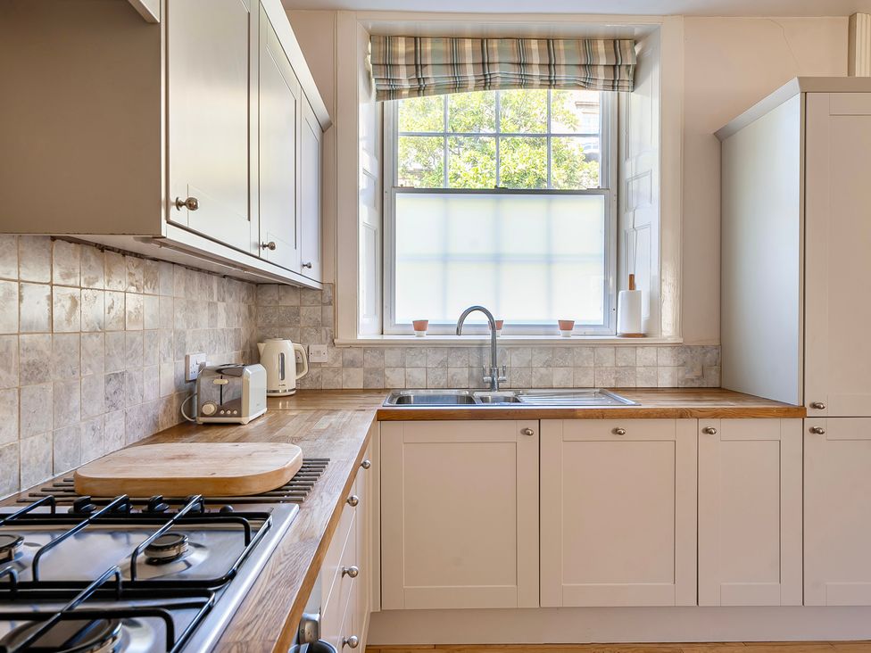 A kitchen with a sink and gas stove at East Wing in Crewkerne