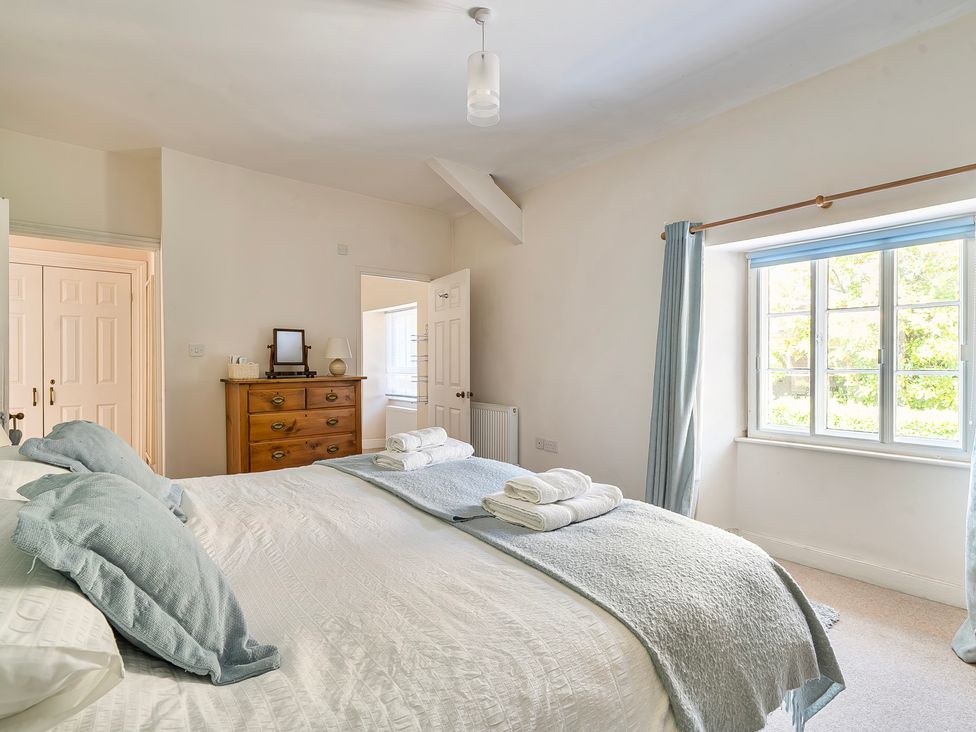 A bedroom with a bed and dresser at East Wing in Crewkerne