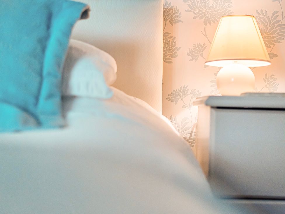 A bedroom with a bed and lamp at East Wing in Crewkerne