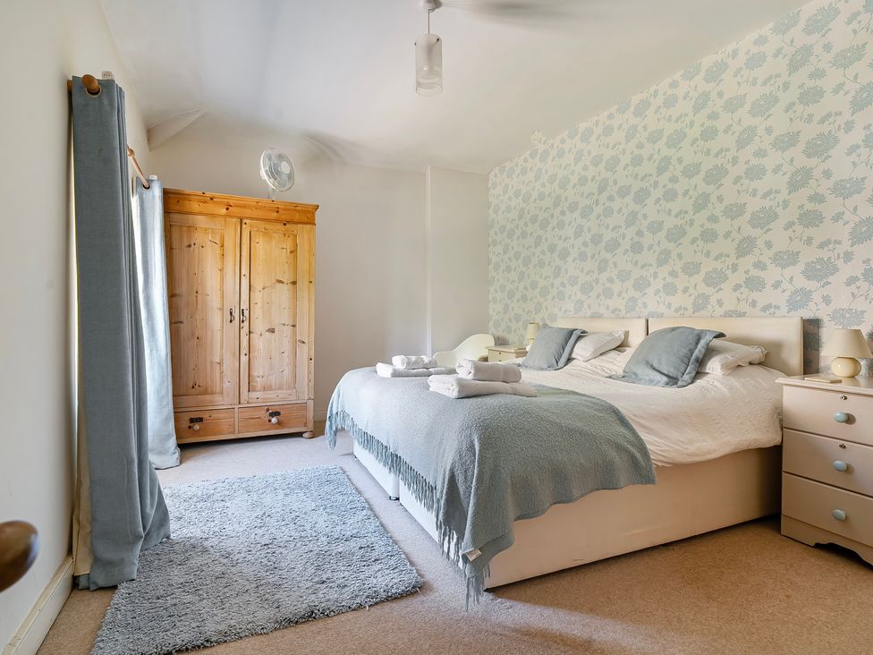 A bedroom with a bed, wardrobe, and nightstand at East Wing in Crewkerne