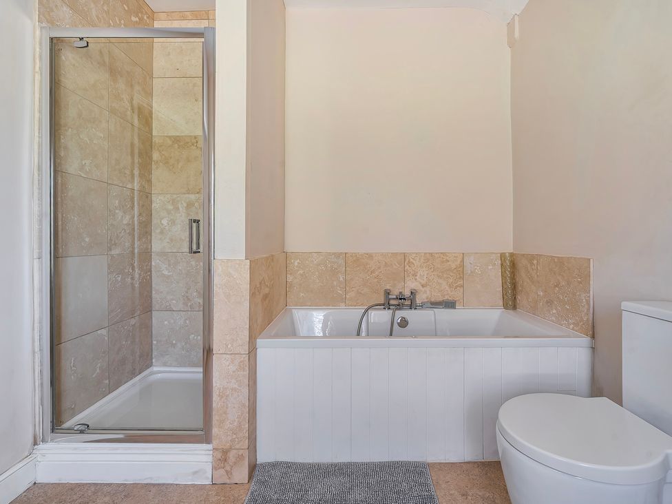 A bathroom with a shower, bathtub, and toilet at East Wing in Crewkerne