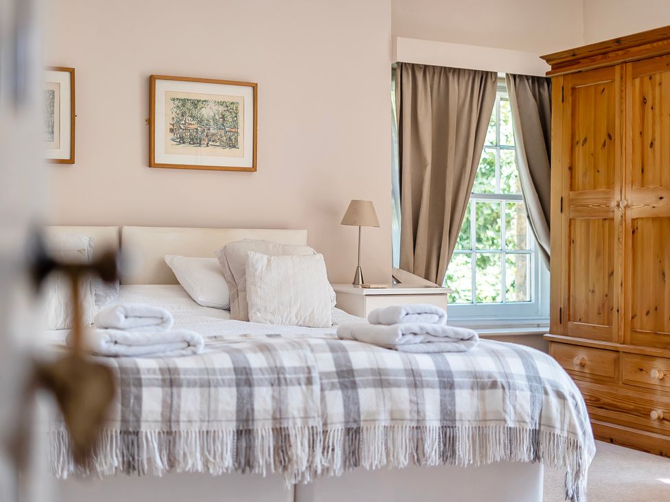 A bedroom with a bed and wardrobe at East Wing in Crewkerne