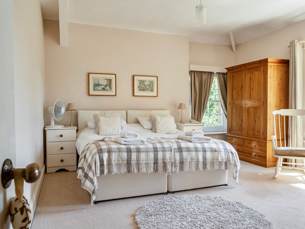 A bedroom with a bed and wardrobe at East Wing in Crewkerne
