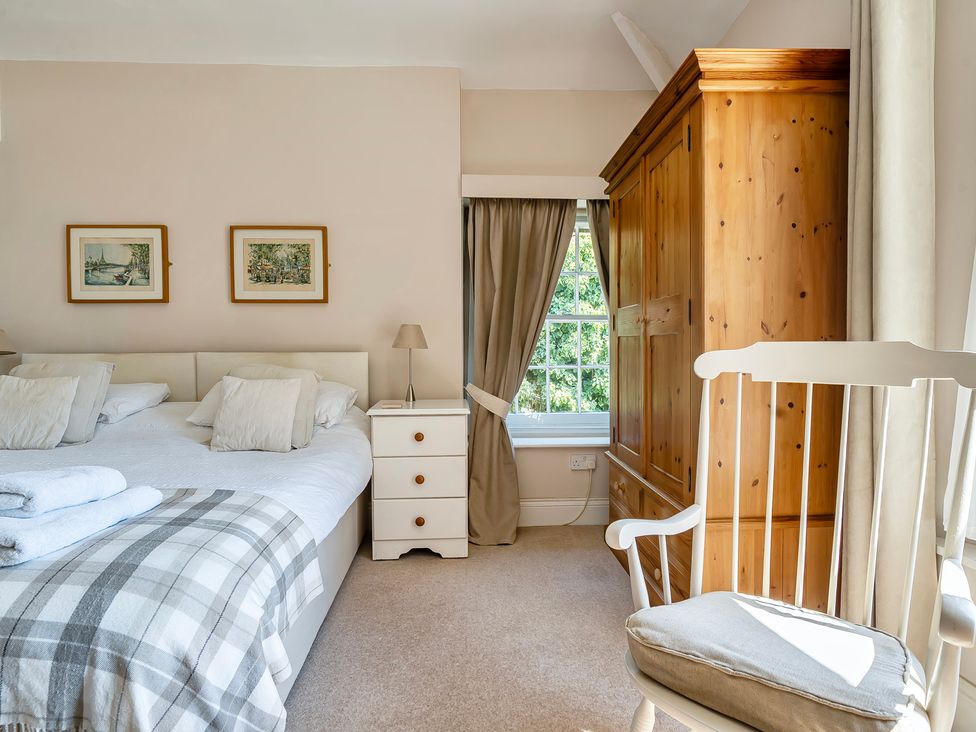A bedroom with a bed and wardrobe at East Wing in Crewkerne