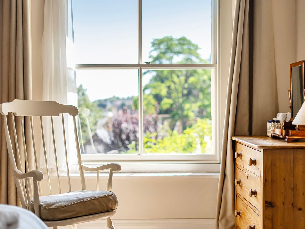 A bedroom with a rocking chair and a dresser at East Wing in Crewkerne